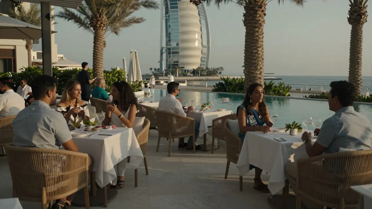 A coastal-style lounge with white linens and a flowing water feature, guests relaxing in rattan chairs as twilight settles.